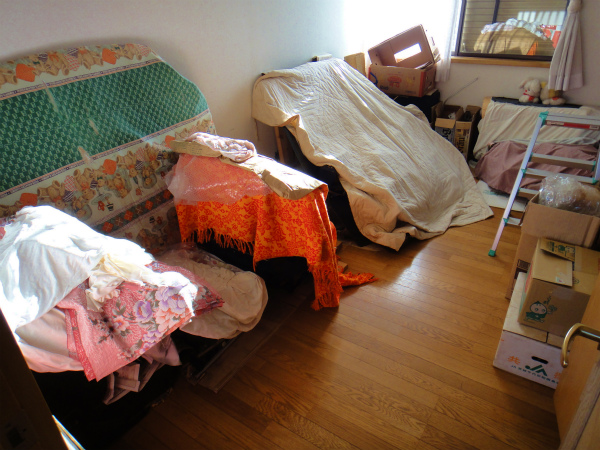自動車のパーツが積上げられた部屋にボンネットを収納